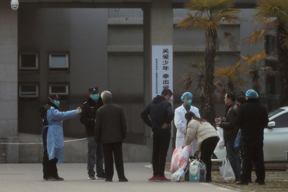 Các nhân viên y tế và nhân viên an ninh ngăn không cho người nhà của các bệnh nhân tới quá gần bệnh viện Jinyintan ở Vũ Hán để phòng lây nhiễm - Ảnh: REUTERS
